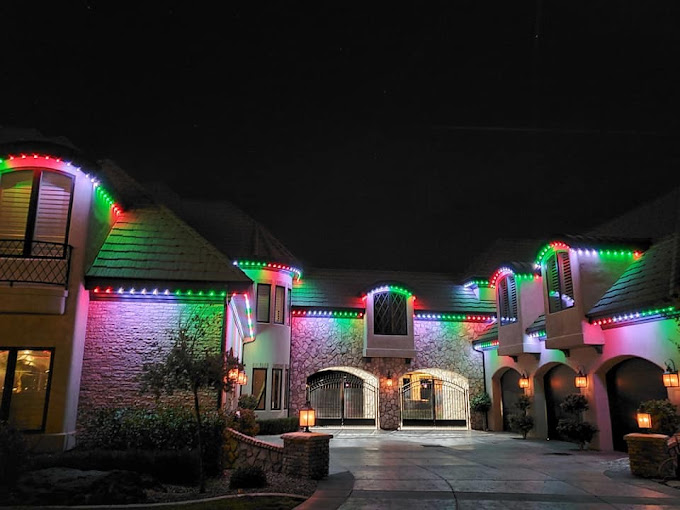 Beautiful home lit up with colorful holiday lights. Permanent lighting systems concept image